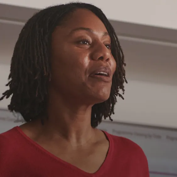 Black lady standing and presenting to colleagues