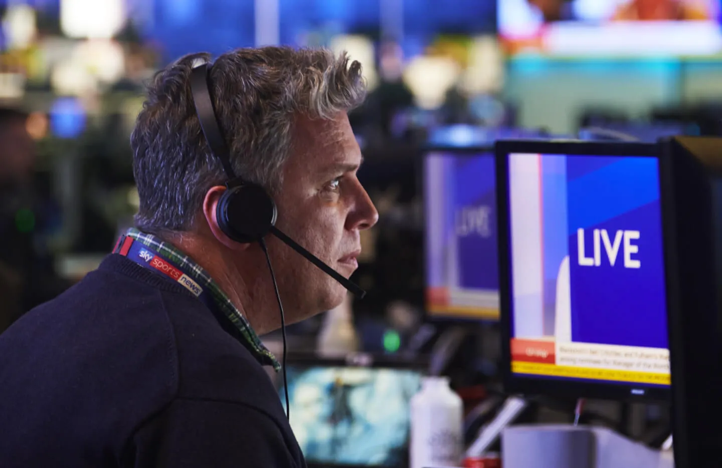 Side view of older male wearing a headset working at a computer